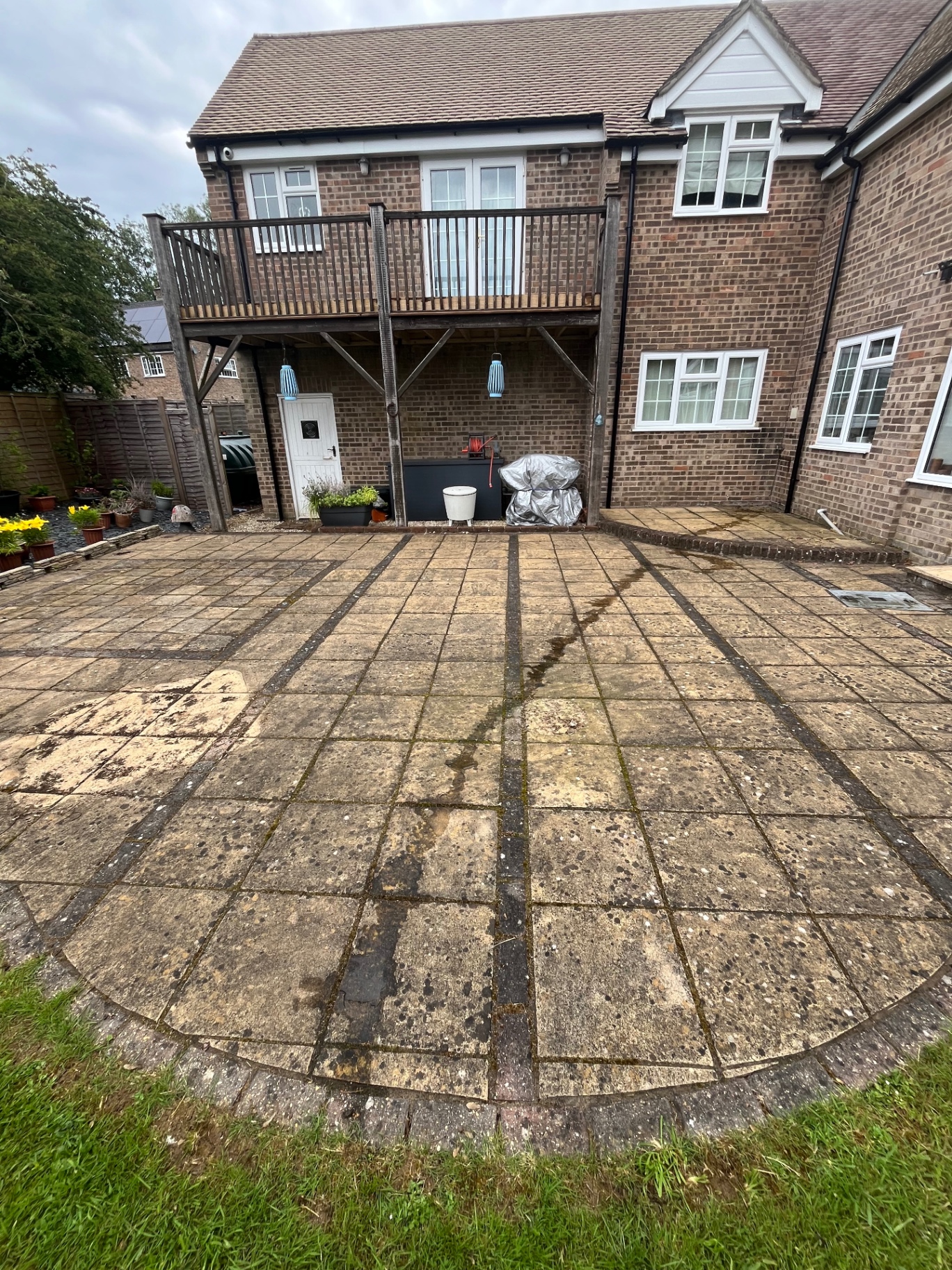 Patio before cleaning showing moss and dirt