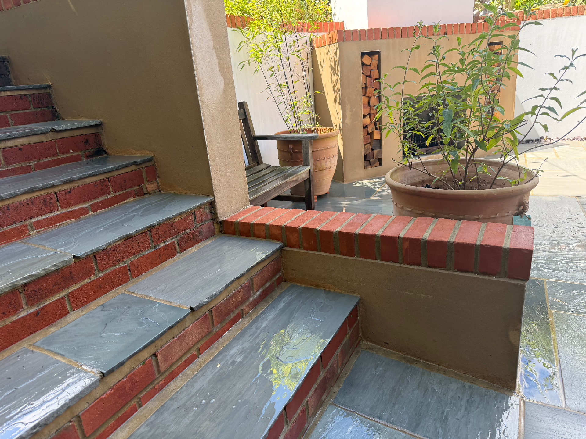 Patio with restored brick step and slate slabs after cleaning