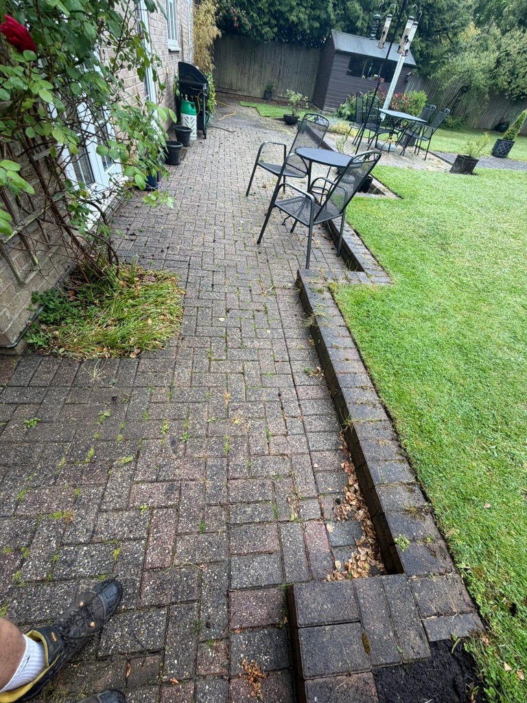 Patio before cleaning with weeds and moss between block paving