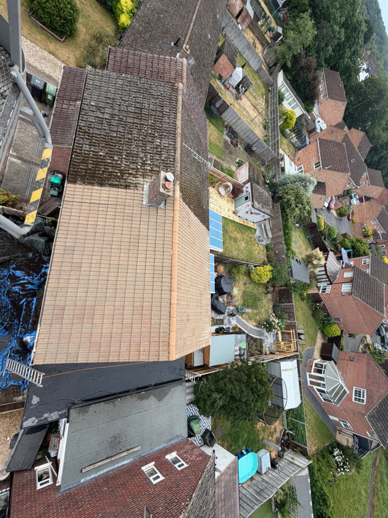 Aerial view of a roof half cleaned showing before and after treatment