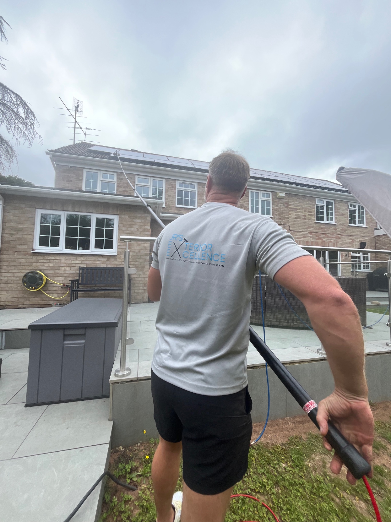 Technician carrying out exterior cleaning work at a property